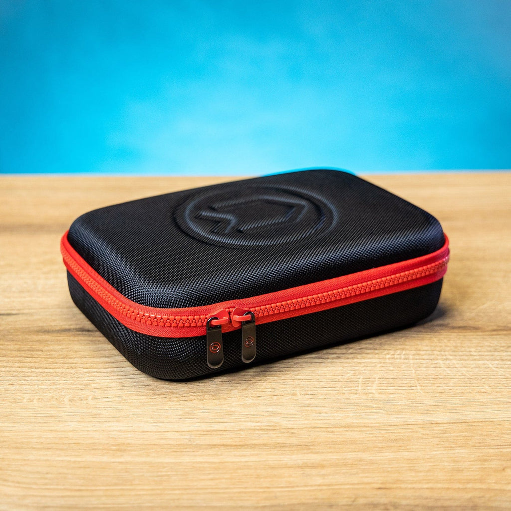 Black case with red zipper on a wooden table.