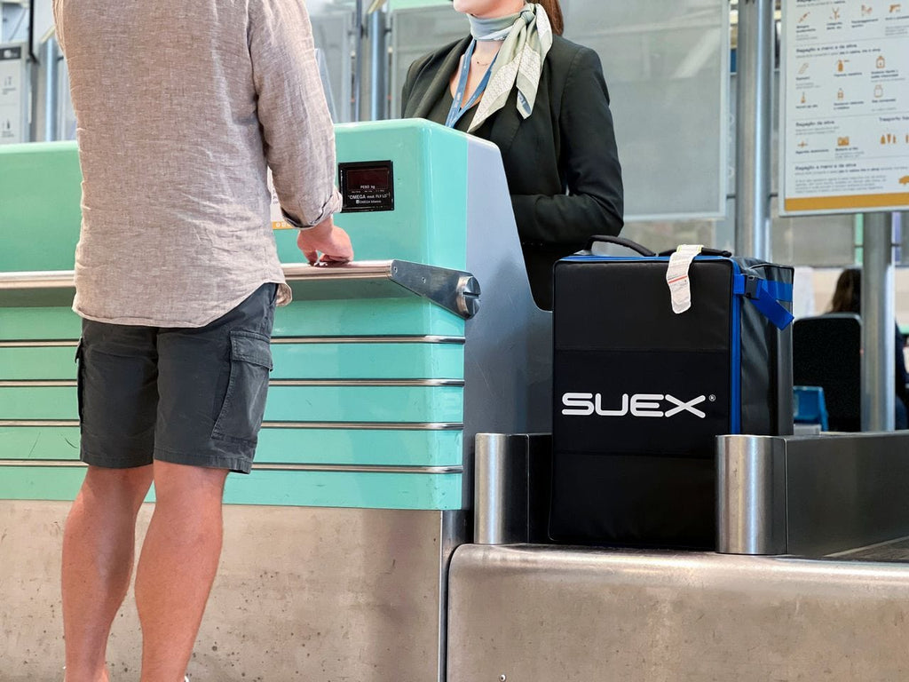Man at airport check-in with SUEX bag (KNUeGCqQ)